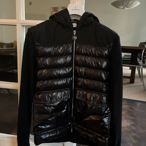 Moncler Cardigan knappt använd - Säljer en Moncler Cardigan somn knappt är använd. Inköpt på NK i våras. Kvitto finns om önskas. Skicket är som helt ny knappt använd.  Säljer pga för stor.  Nypris: 8000 kr