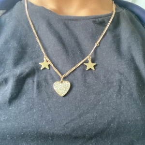 Snygga örhängen - Jag säljer en klämma, ett halsband samt ett par unika örhängen😁. Örhängenas stopp är dessvärre försvunna men om man har ett par hemma kan man använda de. Halsbandet är i guld, två stjärnor och ett hjärtat på halsbandet. Hårklämman är is blad form. 