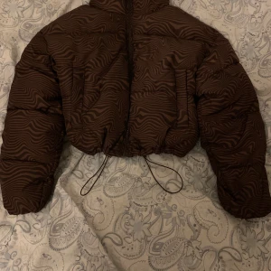 Oanvänd kort jacka  - Ny oanvänd jacka man kan spänna den på sidorna storlek xxs den är oversized tror jag för passar s  Den är varm och man kan ha den på vintern/hösten