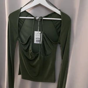 En grön fin topp  - En grön fin topp med snöre som man kan knyta lite hur man vill. Oanvänd. 