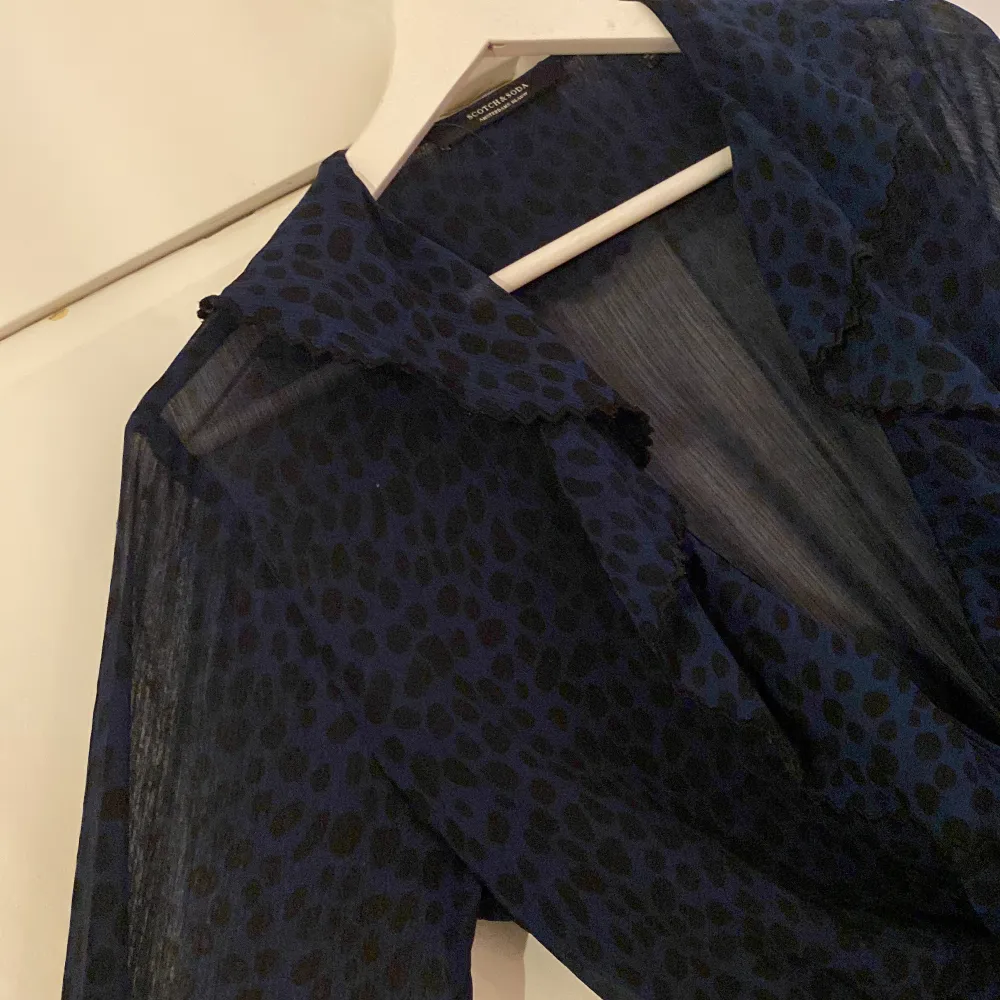 Mörkblå mönstrad sheer wrap klänning med volang detaljer från Scot  ch and Soda. Bra skick . Klänningar.