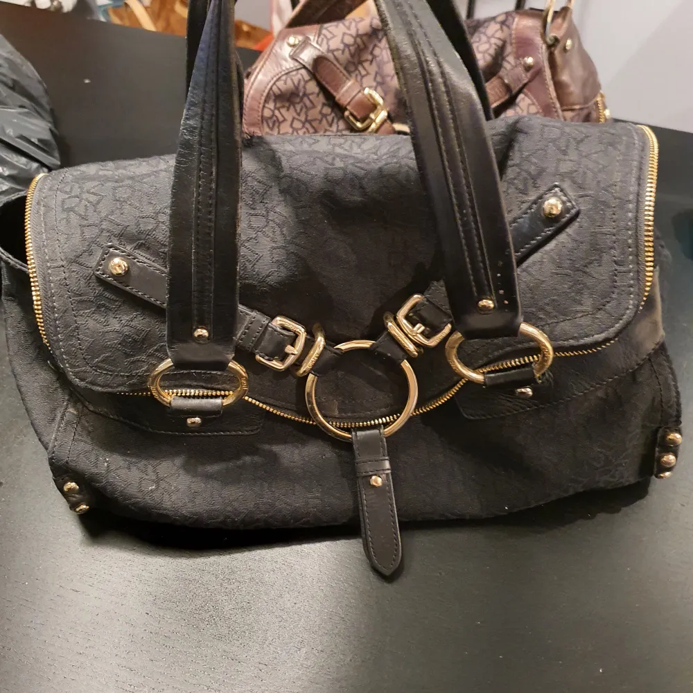 Väska från DKNY, äkta, välanvänd med lite slitage på handtag, se även bild med en skada på tyget.. Väskor.