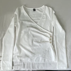 V ringad Tröja - V ringad vit tröja med knappar. SIZE: S men passar bäst folk med storlek XS