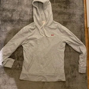 Ljus grå levis hoodie - En fin ljusgrå levis hoddie i nyskick. Snygg och bra passform och nypriss 500kr. Köpare betalar frakt 