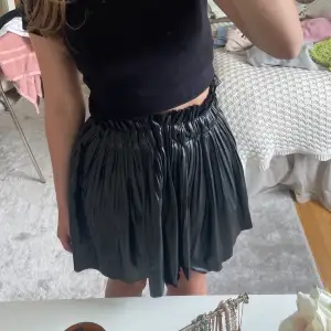 Säljer denna svarta skinnkjol från zara. Den har shorts under som är pösiga så inget oskönt tajt ❤️