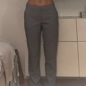 Gråa lågmidjade kostymbyxor - Gråa lågmdijade kostymbyxor, helt oanvända! Innerbenslängden är 75 cm och midjemåttet är 78 cm.       Pris kan diskuteras!