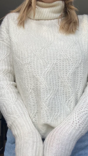 Stickad tröja  - En vit stickad tröja med turtleneck och ett jättefint mönster