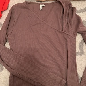 Brun tröja med fin detalj - Tröja från nelly i väldigt fint skick, använd fåtal gånger. Storlek S