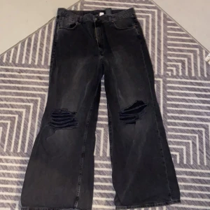 Jeans wide highwaist - Jeans som sitter åt på låren men är fint lösa efter knäna med hål. Självaste färgen på jeansen ser urtvättad ut. 