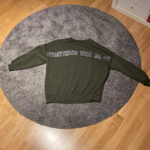 Detta är en bekväm mörkgrön sweatshirt . På sweatshirten står det ”everything will be ok”.Trycket finns på framsidan. Den är i  fint skick men har noppor.