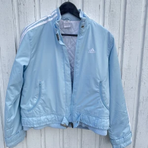 Baby blå adidas jacka  - Säljer min super fina adidas jacka pga att det inte kommer till användning. Den har små vintage detaljer på kragen, armarna och vid blixtlåset. Den är perfelt nu till våren och har den finaste blåa färgen. Den är i storlek S så den sitter typ i midjan💙💙