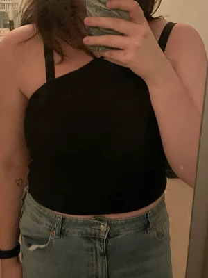 Svart kort topp med korsade band - materialet är lite tjockt aldrig använd  