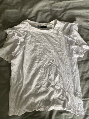 Vit T-shirt  - En vit T-shirt med volanger vid axlarna⭐️Så fin till jeans, kjol etc