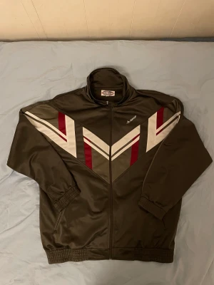 Tracksuit jacka - Vintage tracksuit jacka säljes! Den äe i väldigt gott skick då den inte använts mycket. Storlek X-large. Köparen står för frakt.