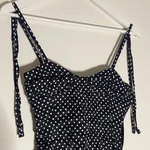 ZARA BODY **DEL AV SET** - Jättefin Zara body som är svart med prickar. Den knäpps där nere med knappar. Aldrig använd, endast testad. Helt ny. Uppe på axlarna kan man knyta rosetter. Del av set. Finns matchande kjol på min profil. Säljer pga fel storlek. ❤️