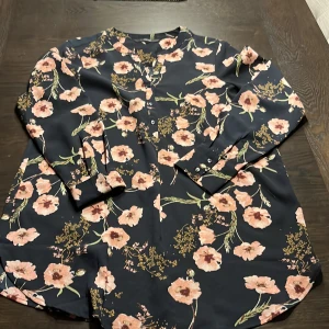 Blommig längre blus  - Fint skick  Polyester /elastan 