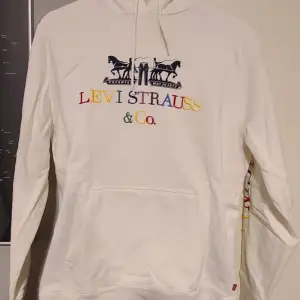 Vit levi's hoodie med tryck på framsidan och på enda ärmen. Knappt använd och i väldigt bra skick. Storlek S