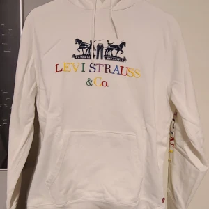 Levi's Hoodie - Vit levi's hoodie med tryck på framsidan och på enda ärmen. Knappt använd och i väldigt bra skick. Storlek S