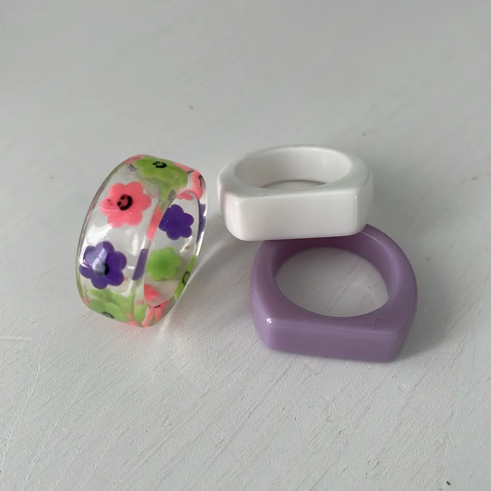 Tre ringar i vit/lila/flerfärgad, ej använd.. Accessoarer.