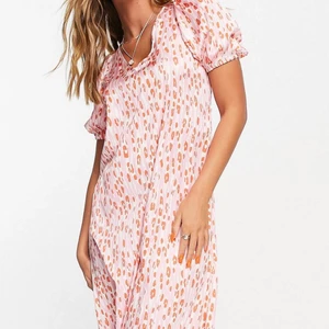 Rosa och röd klänning med öppen rygg - Supersöt rosa och röd klänning, öppenrygg med knyte. Storlek 34, aldrig använd med lappen kvar!