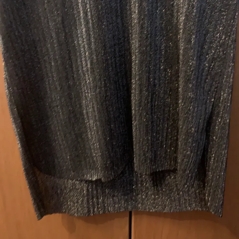 En grå glittrande tröja, framsidan är kortare än baksidan . Tröjor & Koftor.