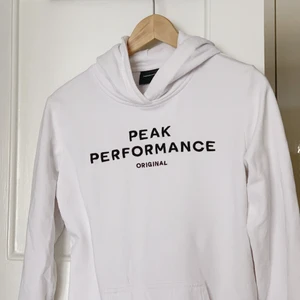 Vit Peak Performance hoodie (stl 170) - Säljer en sååå skön hoodie från Peak Performance, så gott som oanvänd. Köpt från barnavdelningen så i stl 170, men passar toppen till mig som är XS-S. 🤍   Nypris: 749:- Säljes för: 200:-