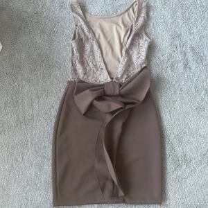 Klänning  - Klänning med rosett och öppen rygg 