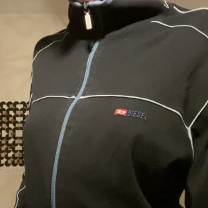 Diesel zipup - An svart tjocktröja med vita och ljusblåa detaljer, super skön