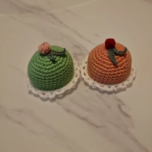 Virkade små tårtor - Dessa virkade bakelser haj jag gjort själv. Garnet är av bomull. Tårtorna är ca 4 cm hög. Båda trårtor för 75. Köparen står för frakten (29kr)