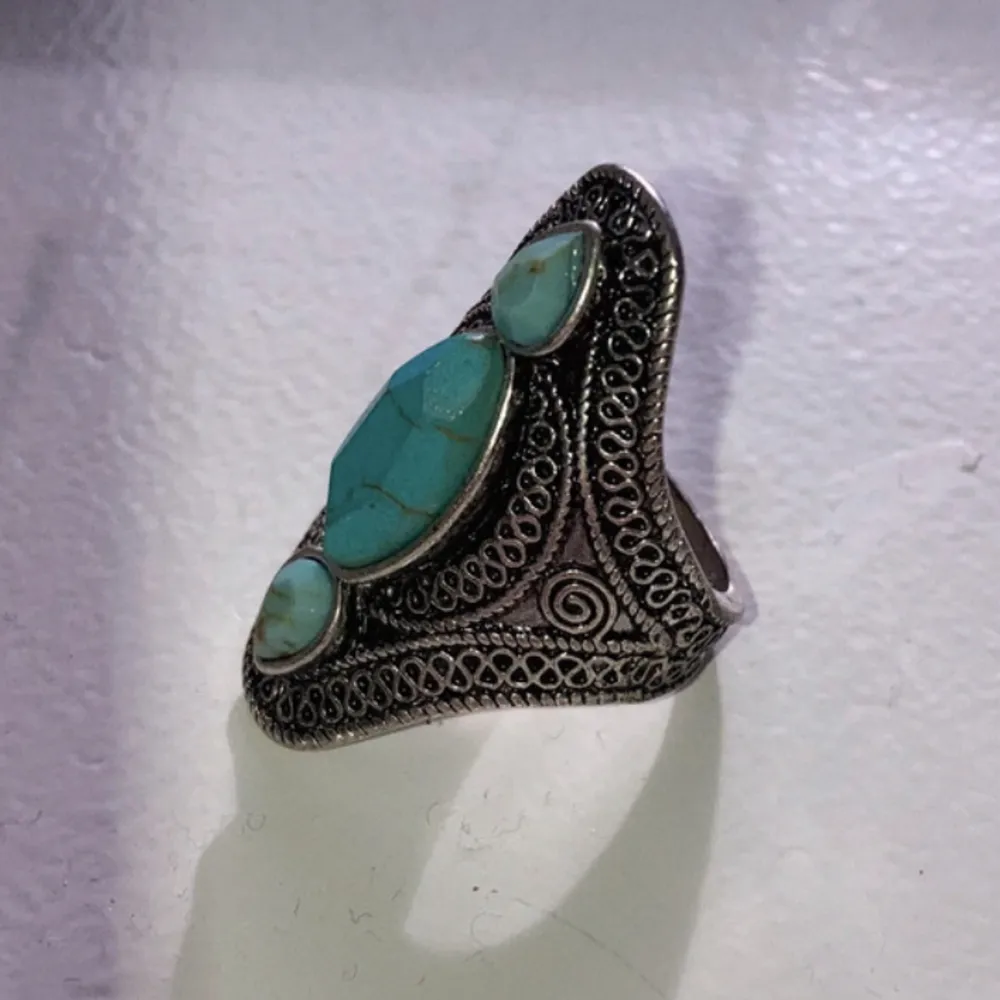 Ring i silverfärg med turkosa stenar, mönstrad, 19 mm i diameter. Accessoarer.