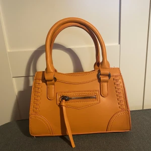 Handväska - En liten men rymlig väska från Gina, nypris 399kr, knappt använd, axelbandet går att ta av, fack med dragkedja i. Mått: 22x14x8. Frakt tillkommer!!!!