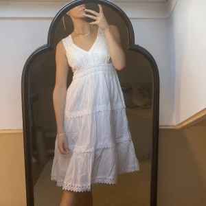 Klänning med crochet - Vit klänning med virkade detaljer. Superfin till midsommar/student. Köpt i Spanien, märke står ej. Aldrig använd.