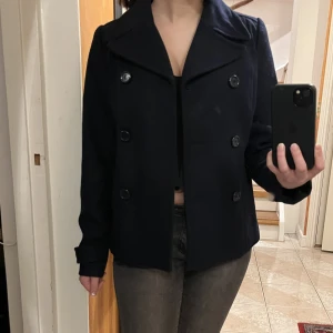 Marinblå kappa - Säljer denna fina korta marinblå kappan från H&M. Knappt använd, säljer pga den inte kommer till användning. Storlek xs, 34. Snygg att stänga eller ha öppen, perfekt för våren!🥰köpt för 500kr.💕Pris kan diskuteras!
