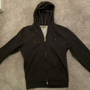 Burberry ziphoodie L - Tja! Säljer min super fina Burberry zip hoodie då jag behöver spara pengar till och köpa en moppebil. Tröjan är liten i storleken och passar mig perfekt som är runt 180. Tröjan är i nyskick. 9,5/10. Skriv för fler bilder!