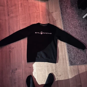 Sail racing tröja - En fin och knappt använd sail racing sweatshirt i färgen svart och storlek 160/xs. Fick den i present av släkten, men redan då var den på gränsen för liten så har knappt använt den. Inga märken, stänk eller missfärgningar utan den är helt exemplarisk.