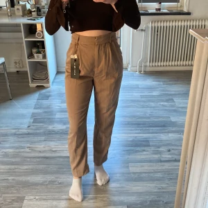 Beige kostymbyxor  - Helt nya kostymbyxor med prislappen kvar. Storlek 32 