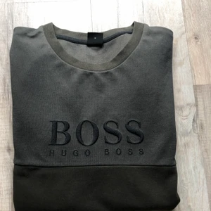 Hugo Boss Tröja - Säljer min mörk gröna Hugo Boss tröja. Endast använd ett fåtal gånger, väldigt  bra skick. Storlek M men passar även L, skicka för mer info!