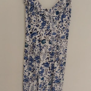 vit- och blåblommig jumpsuit. - Dragkedja i ryggen.  Material 100% viskos  Sparsamt använd men har blivit för liten.  