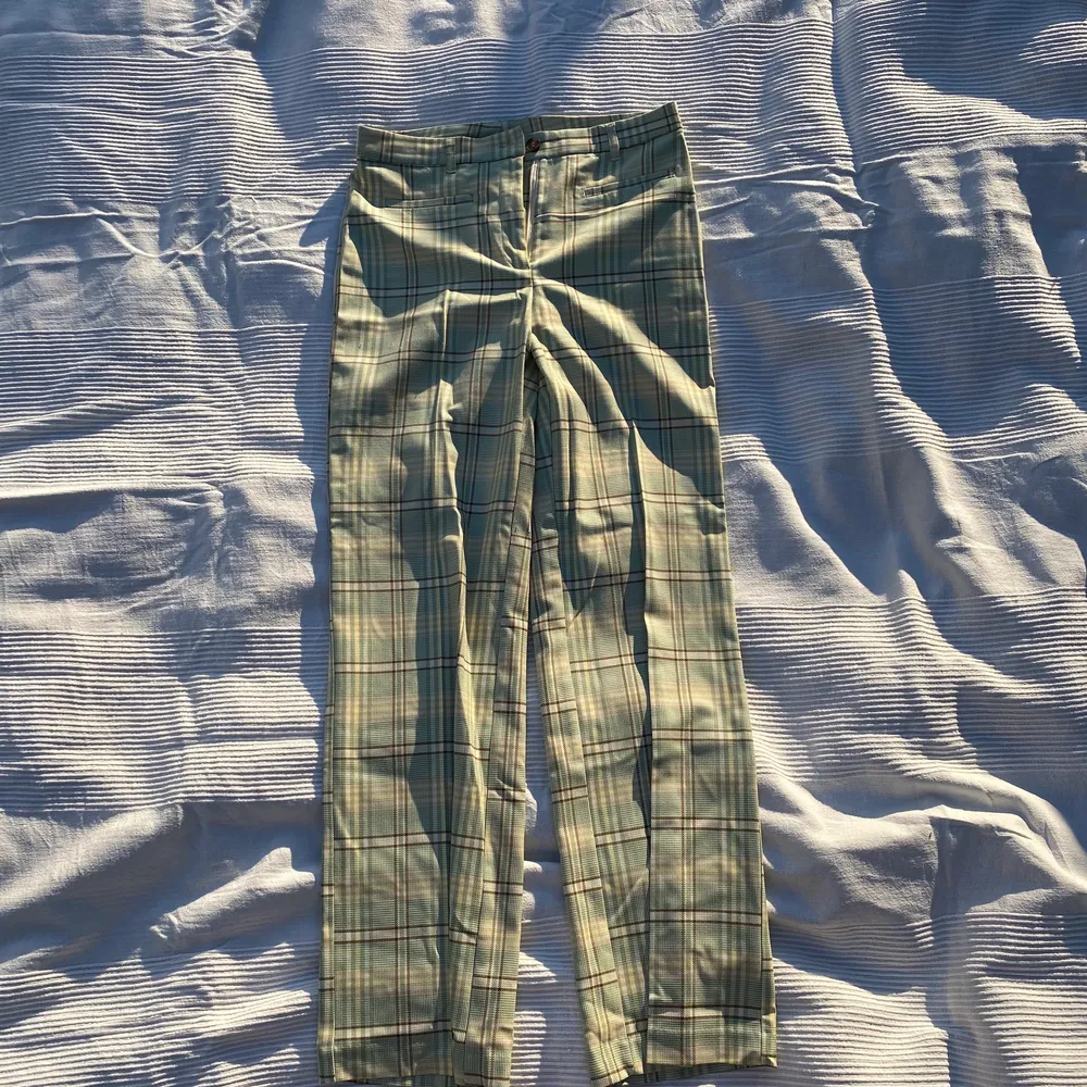 Ett par gröna rutiga byxor, med bruna, vita och gula detaljer. Extremt fina men aldrig använda.  . Jeans & Byxor.