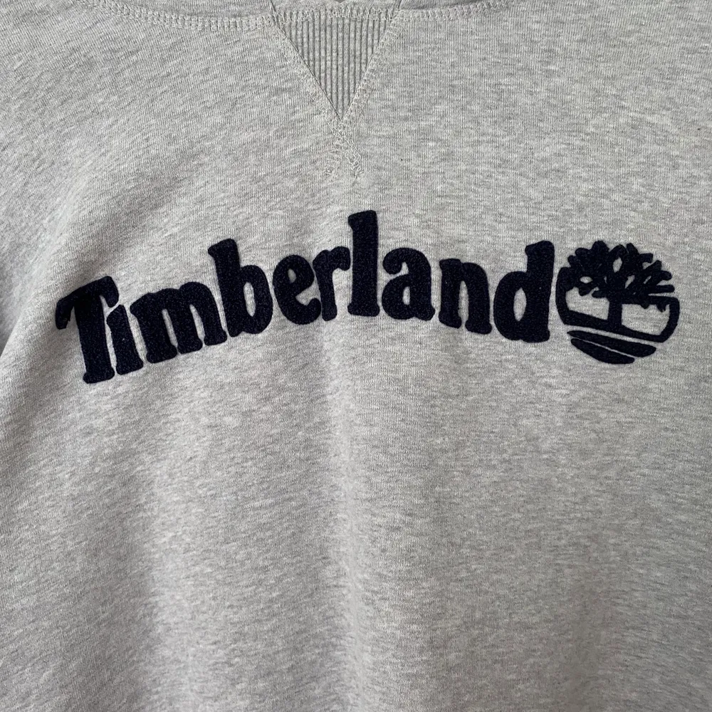 Grå Timberland hoodie i storlek L. Väldigt bekväm och snygg. Trycket är i marinblått.  . Hoodies.