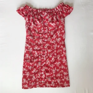 Röd blommig klänning  - Röd tajt klänning med vita blommor, of shoulder puffärmar, ganska  stretchig ♡ Skriv helst innan du köper, är villig att diskutera pris och ställ gärna frågor ♡