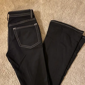 Weekday - Svart bootcut jeans med vita sömmar från weekday, sitter midrise, aldrig använda, ganska långa i benen