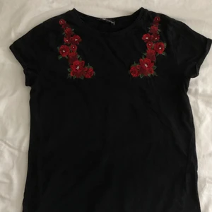 Blommig T-shirt  - Blommig svart t-shirt från New Yorker. Bra skick. Storleken är xxs men den sitter som en xs