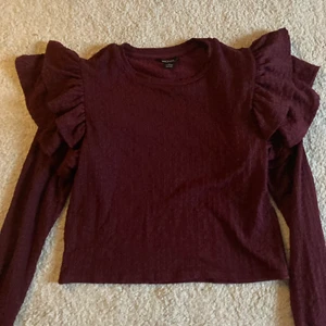 Vinröd volangtröja - Säljer superfin volangtopp från Monki! Köpt för 299kr! 