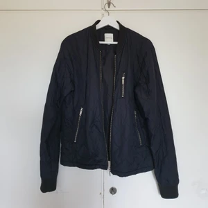 Jack & Jones Bomberjacka strl M - Mörkblå bomberjacka från Jack & Jones strl M, quiltat tyg. Fint skick.