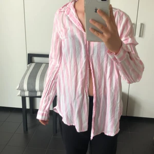 Rosa, vit randig skjorta - Säljer denna jättefina skjortan som är köpt secondhand, men används aldrig. Man kan ha den öppen, knäppt, oversized… den är lika fin hur som helst!💗💗