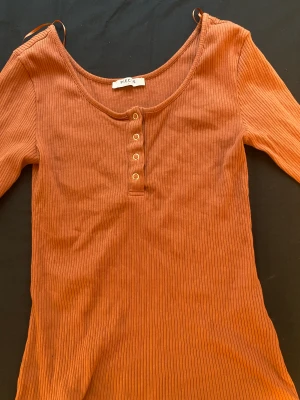 Orange topp - En helt ny topp som aldrig använts. Den är lite för stor på mig samt så passar inte färgen. Den är väldigt fin och det går även att knäppa upp knapparna. 