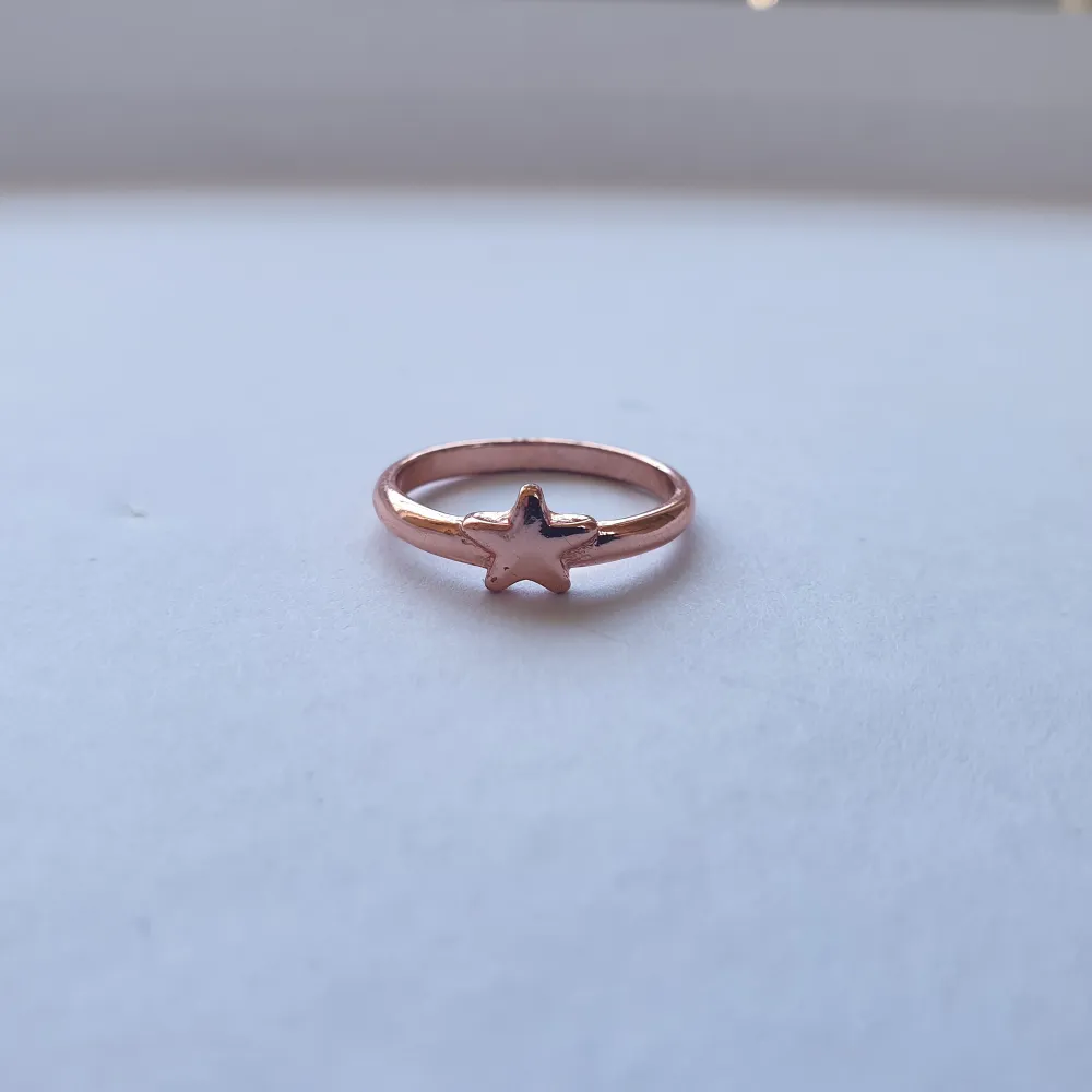 En bronsfärgad ring med stjärna på, nästan helt oanvänd. . Accessoarer.