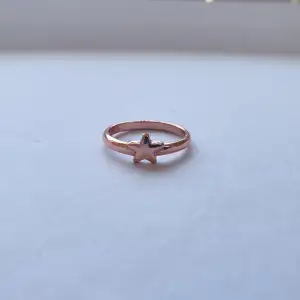 En bronsfärgad ring med stjärna på, nästan helt oanvänd. 