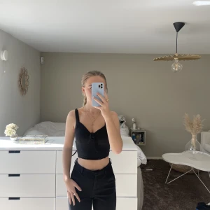 Svart topp med knyte - En svart tight topp med knyte vid bröstkorgen. Använd fåtal gånger. Köparen står för frakten;)